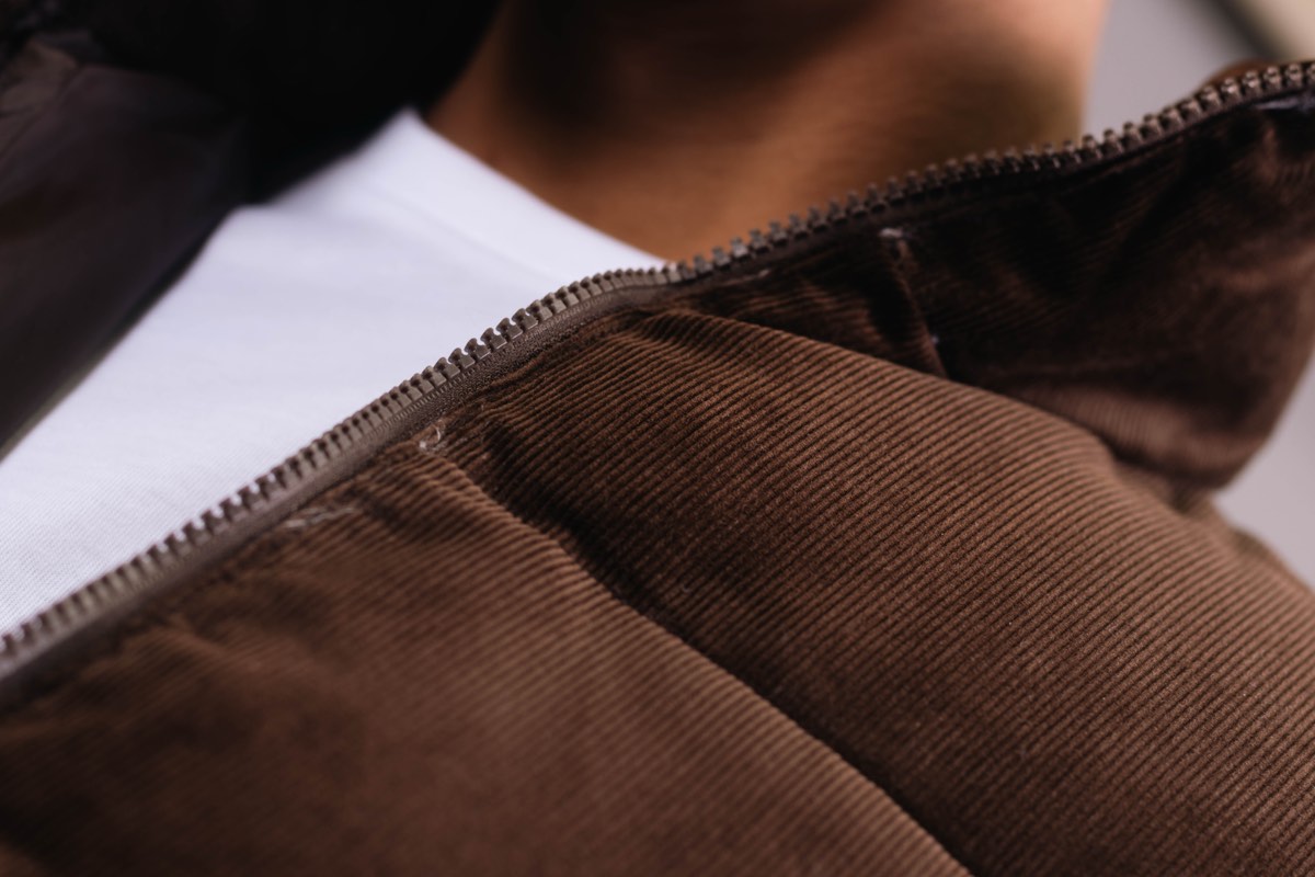 Macro detail of ribbed corduroy fabric in deep brown, from an apparel brand content shoot